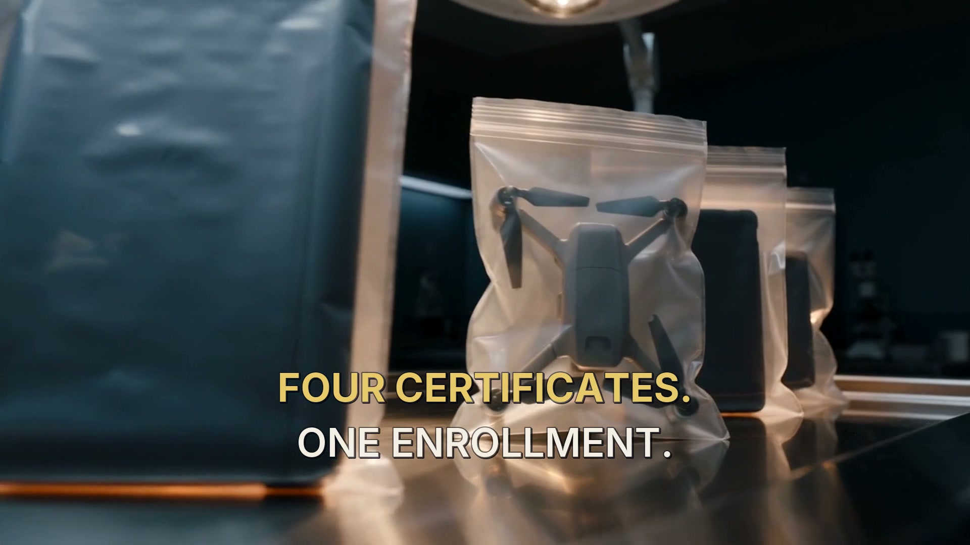 Four sealed evidence bags on a forensic intake table: laptop, phone, drone, and storage media.