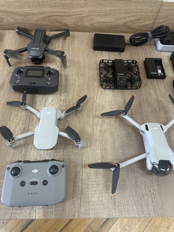 Several drones and controllers laid out on a bench for forensic examination